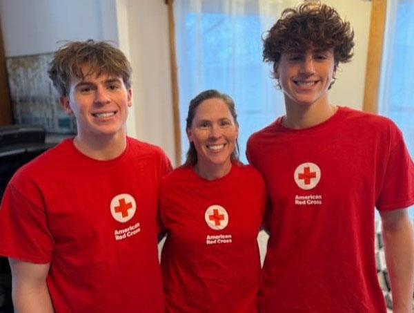 Rebecka Wittenstorm and her teenage sons, Lukas and Xander wearing Red Cross shirts and smiling for the camera.