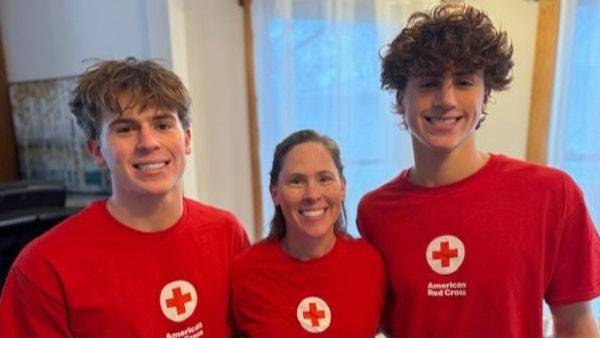 Rebecka Wittenstorm and her teenage sons, Lukas and Xander wearing Red Cross shirts and smiling for the camera.