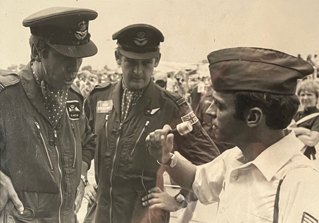 A vintage photo of Rich Dansizen in an Air Force uniform talking to two people in Air Force uniforms.