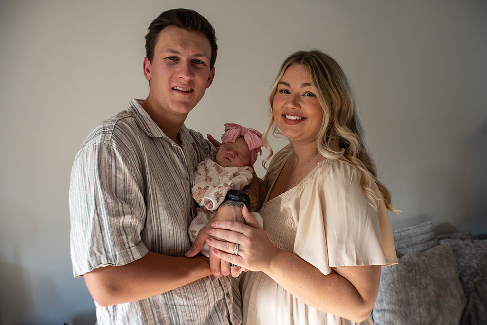 Tessa Troike-Barnett and her husband Bryce holding their new born daughter, Dani.