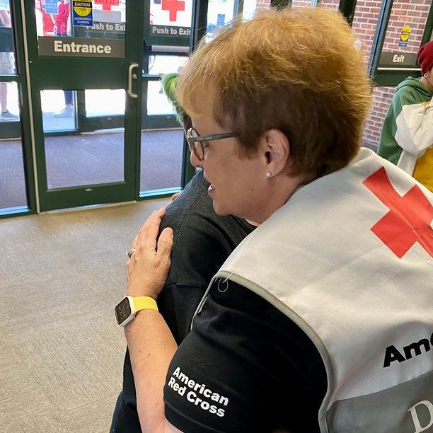 Red Cross volunteer hugs local resident