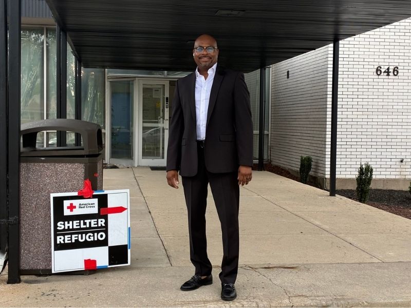 pastor lawrence blackful jr. standing in front of shelter signage