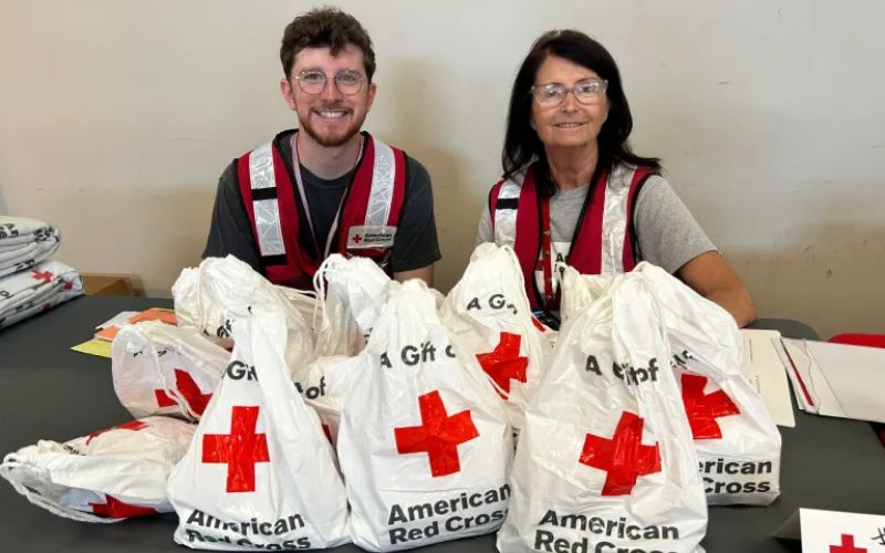 disaster volunteers sitting at table with red cross giftbags