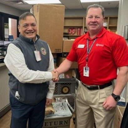 Red Cross volunteer and veteran shaking hands.