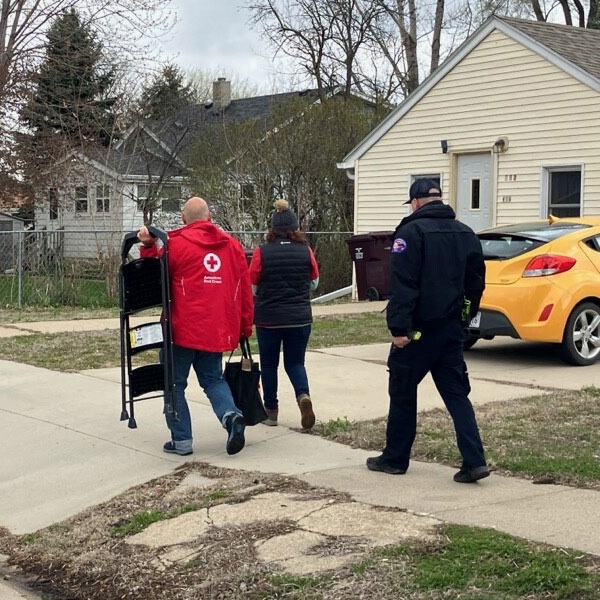 Red Cross volunteers walking to install smoke alarms.