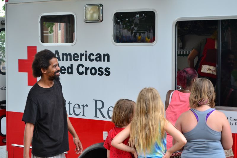 Demarco Clayton (left) looks on as his neighbors at Savanna Landing receive meals from Red Cross volunteers in an emergency response vehicle. The apartment complex was without power for several days, with some residents getting theirs back before others.