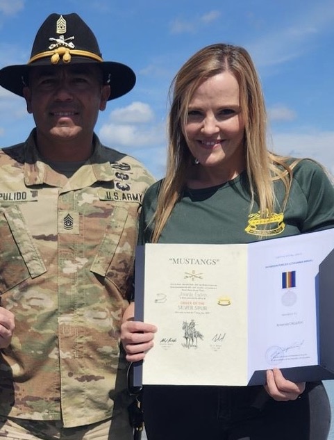 Red Cross SAF Regional Program Manager Amanda English displays her “Order of the Spur” certificate with CSM Alejandro Pulido upon completion of the grueling multi-day challenge.