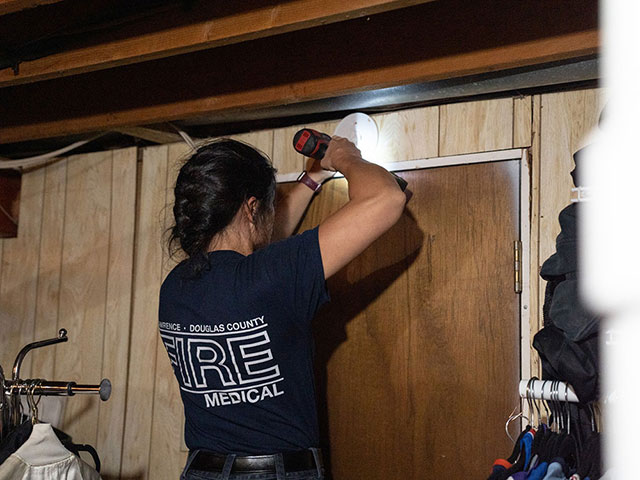 Lawrence-Douglas County Fire Medical personnel installing a smoke alrm in a home.