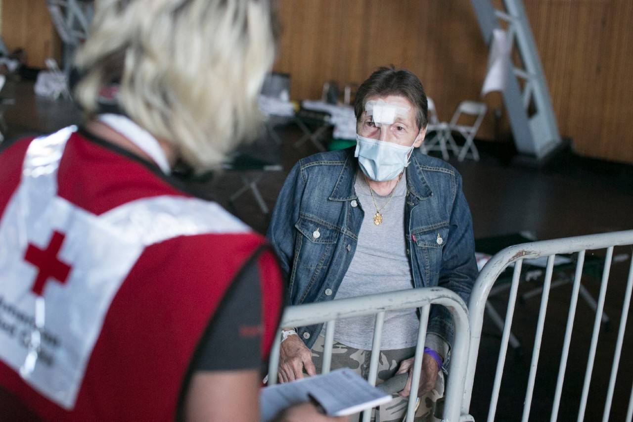 August 22, 2020. Santa Rosa, California.
Red Cross shelter at the Sonoma County Fairgrounds in Santa Rosa, California. 
Red Cross volunteer Jillian Robertson talks to shelter client Fred Mills, who came to this very same Red Cross shelter back in 1995 when another wildfire affected his home.
Photo by Dennis Drenner/American Red Cross