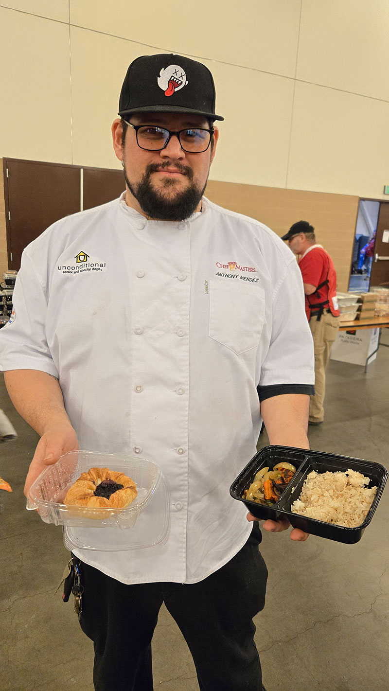 Chef Anthony Mendez holding prepared food for people at a shelter.