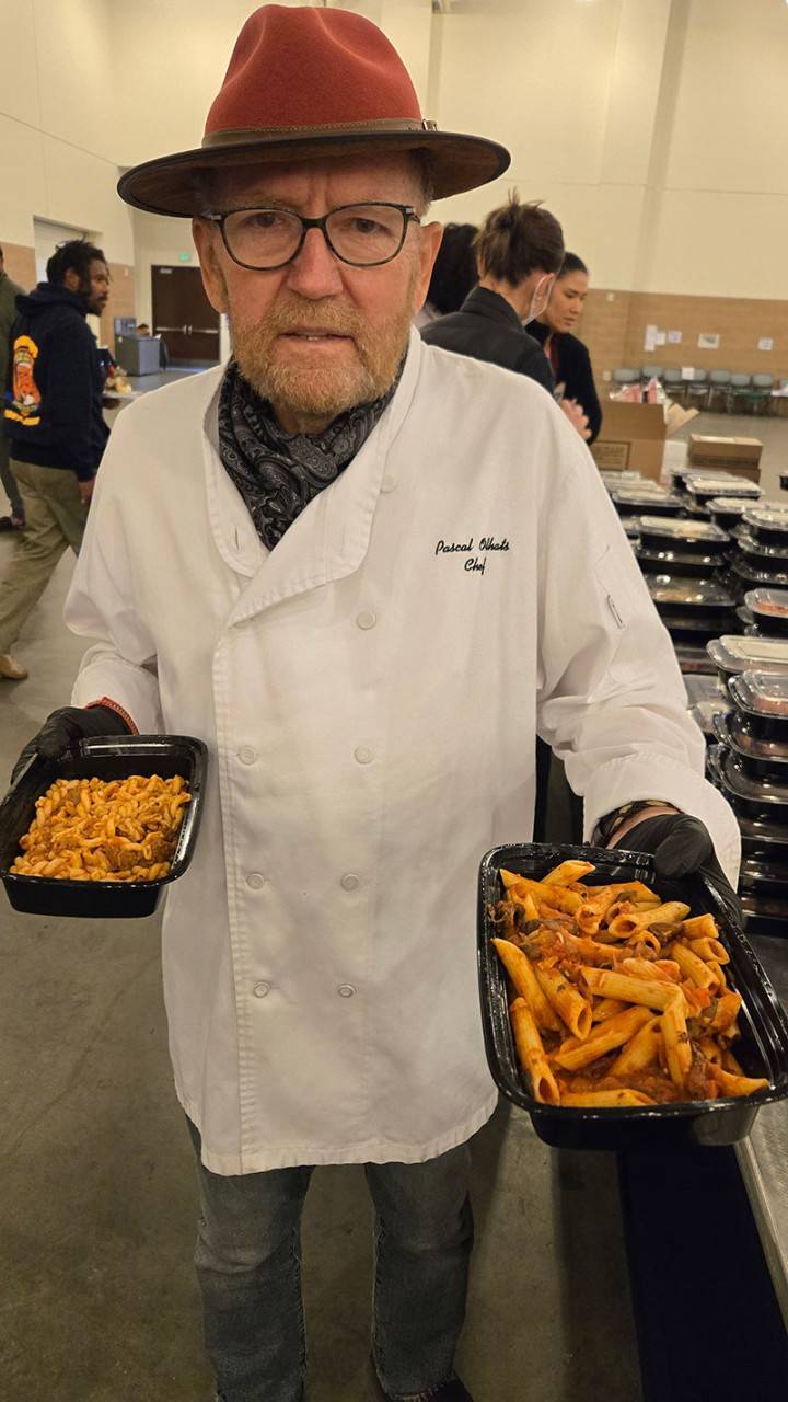 Chef Pascal Olhats holding prepared food for people at a shelter.