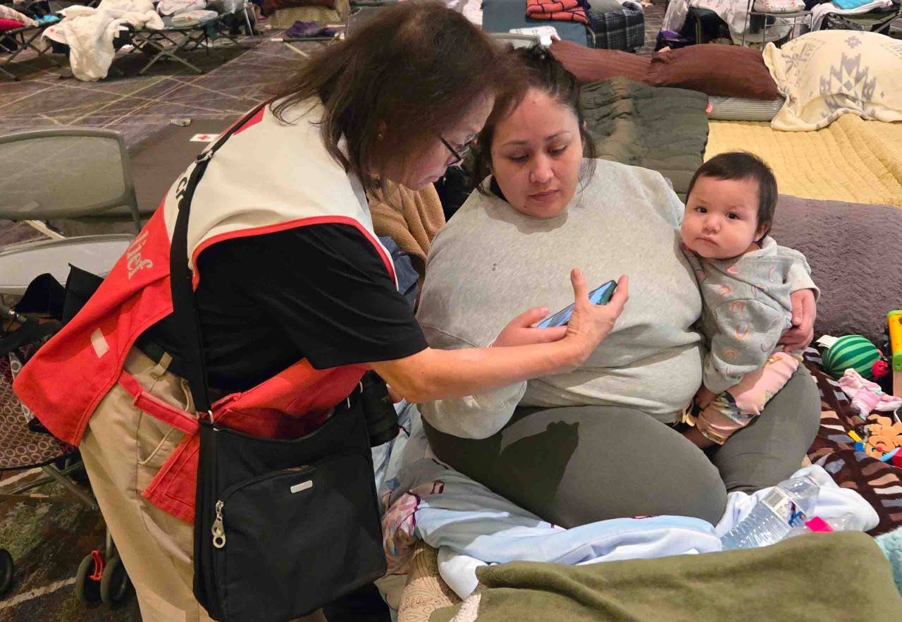 Rosa Olvera and her baby speak with a Volunteer