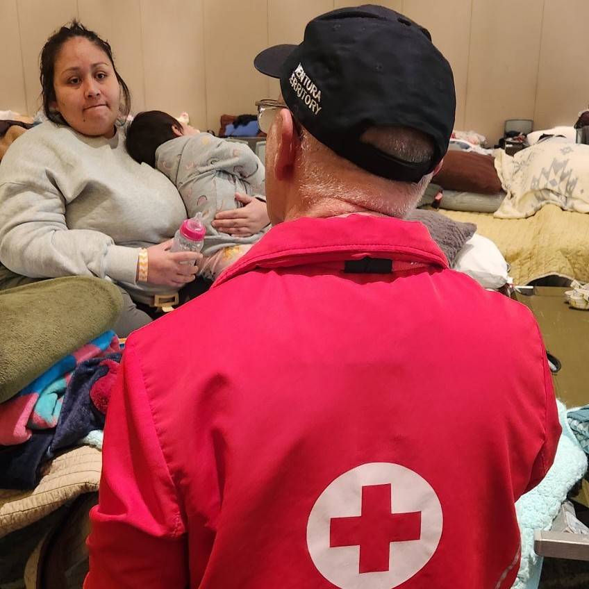Rosa and her baby speak with a Volunteer