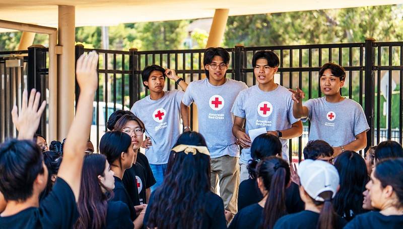 Four Red Cross volunteers teaching youth at a youth camp.