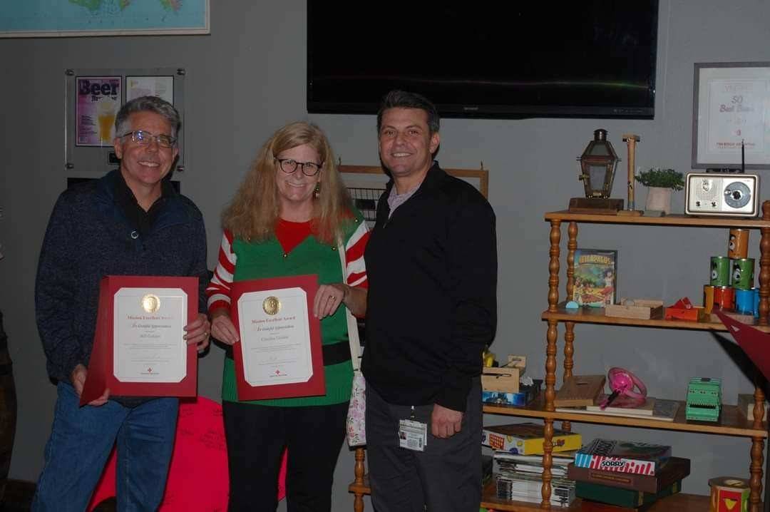 Caroline and Bill Golden holding recognition awards for their committment to the Red Cross mission.