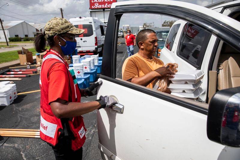 September 2, 2020. Lake Charles, Louisiana
Michele Grady of the American Red Cross hands out meals at a drive-thru distribution point for families affected by Hurricane Laura in Lake Charles, LA on Wednesday, September 2, 2020.
Photo by Scott Dalton/American Red Cross