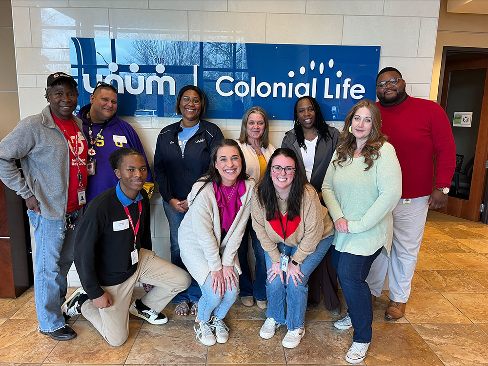 group photo of red cross volunteers and unum employees in the lobby of the unum building.