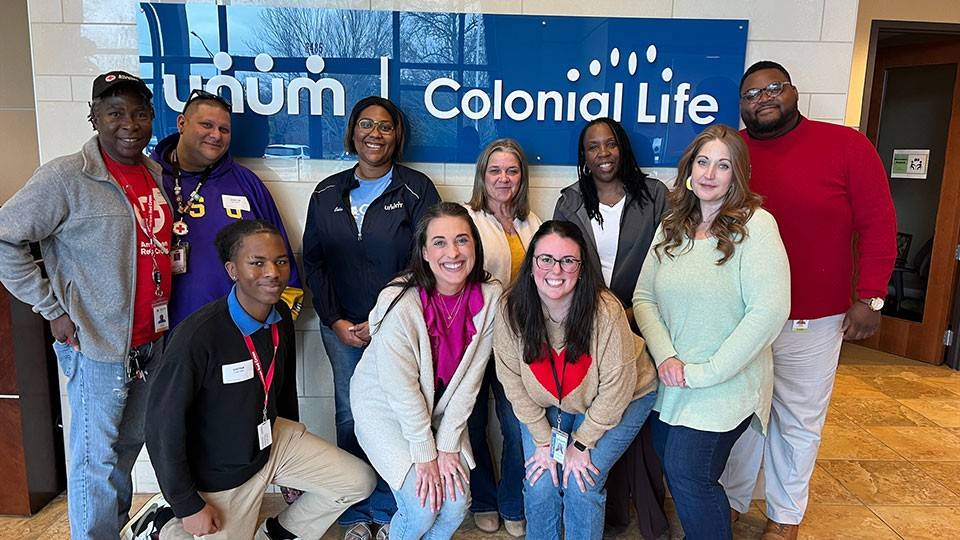 group photo of red cross volunteers and unum employees in the lobby of the unum building.