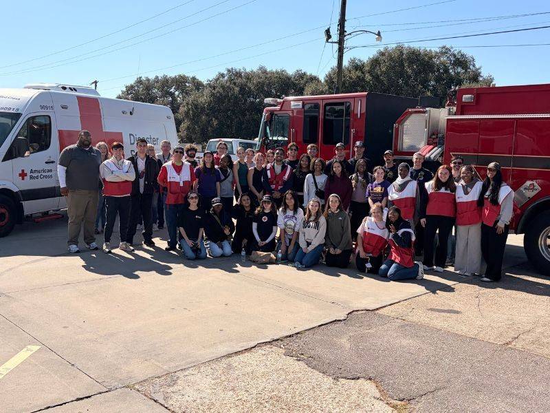 group of red cross volunteers in front of fire truck for sound the alarm