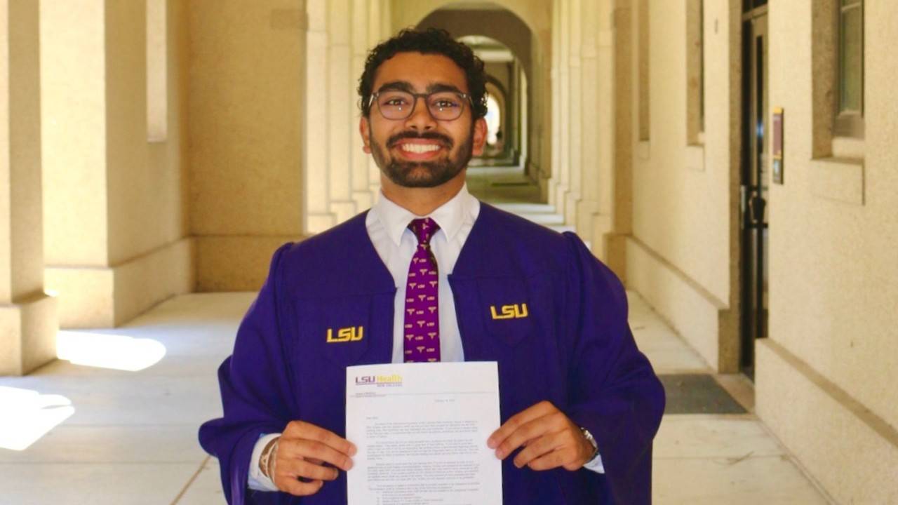 mihir in graduate cap and gown holding certificate