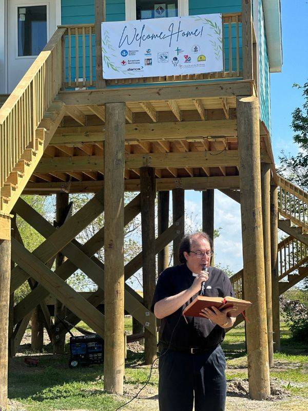 person speaking at house entrance