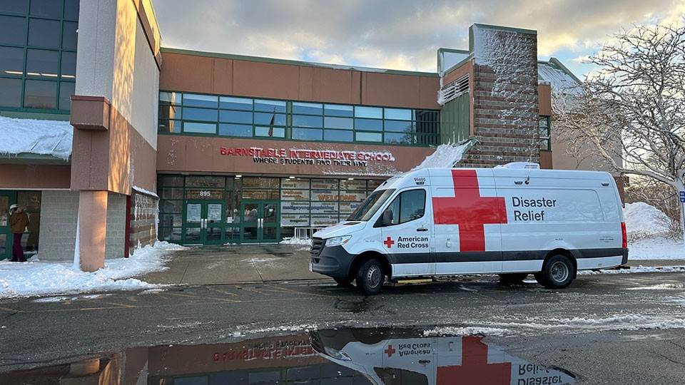 Red Cross vehicles in front of emergency shelter.