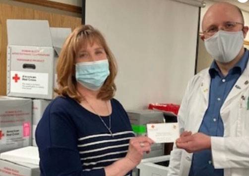 Mary Eddy with a fellow teacher wearing masks and holding Super Bowl ticket.