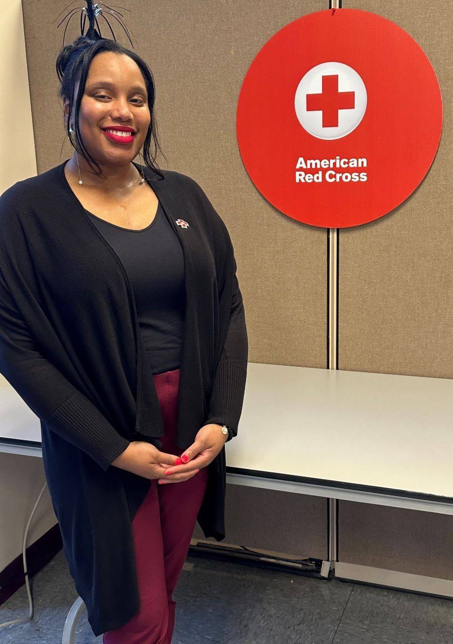 Woman smiling next to American Red Cross sign