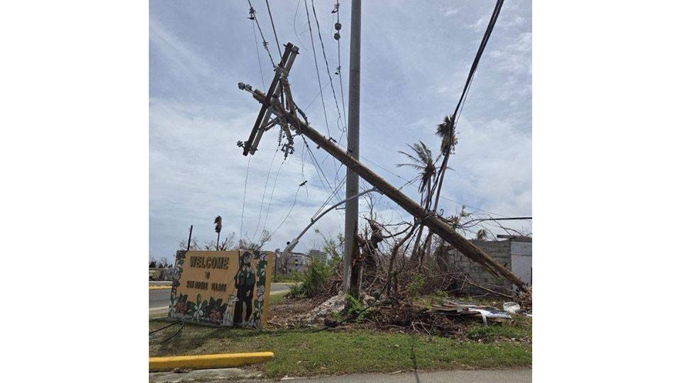 a fallen telephone pole next to the side of the street.