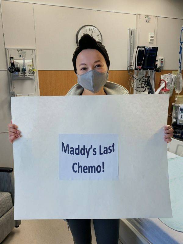 madelyn holding signage for her last chemo treatment