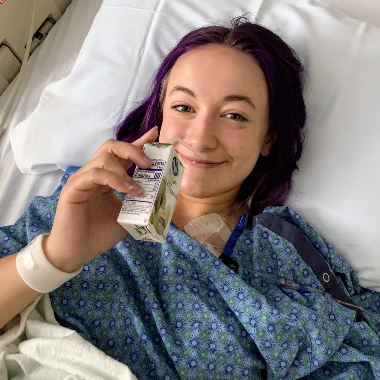 madelyn in hospital bed with juice in hand