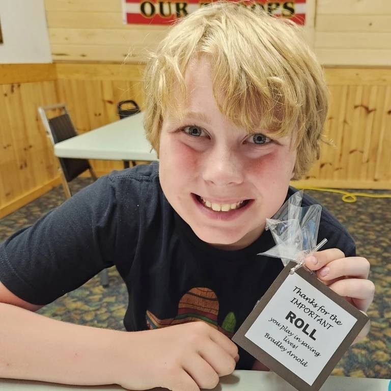 Bradley holding a sign thanking donors for giving blood