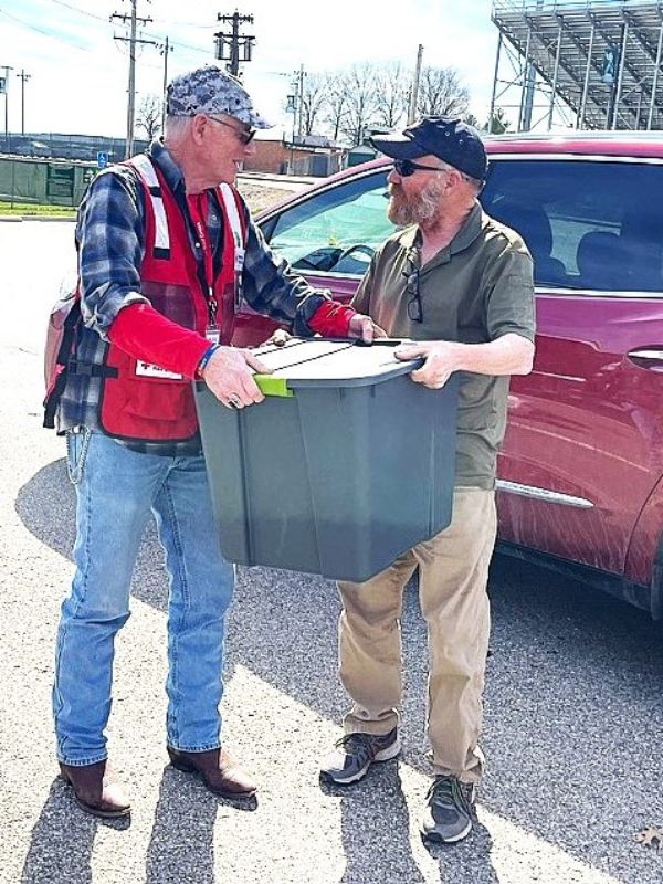 volunteer bob handing box to man.