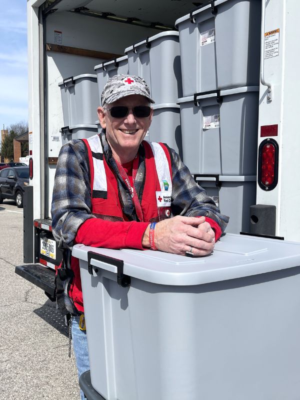 volunteer bob quin next to packaged boxes.