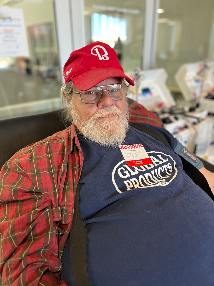 Dan McEntee sitting in chair and donating blood.
