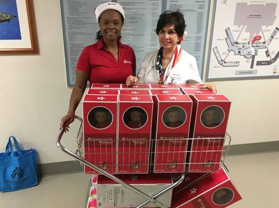 Red Cross volunteers with cart full of American Girl Dolls