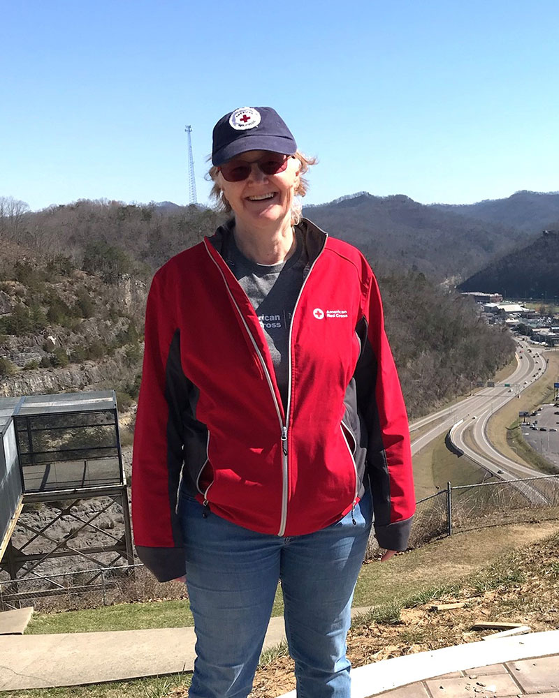 Gwenda Fleming wearing a Red Cross shirt, jacket and hat.