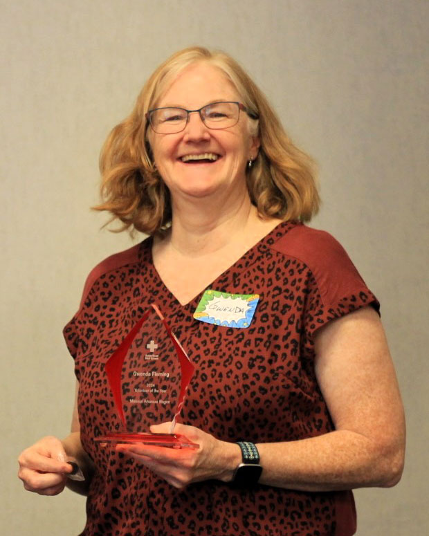 Gwenda Fleming holding a Red Cross volunteer of the year award.