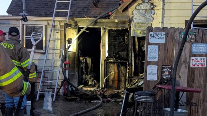 firefighters at a house with fire damage.