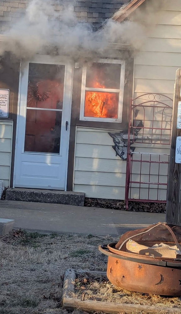 the front door of a house with flames in the window.