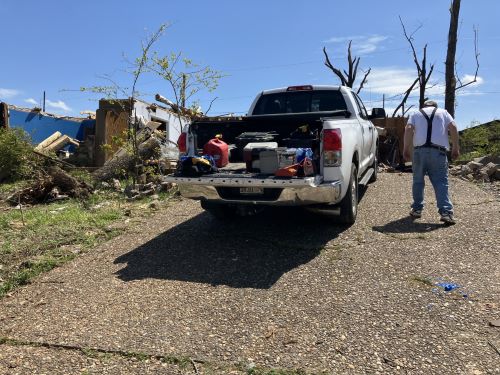 A man in front of his home cleaning up