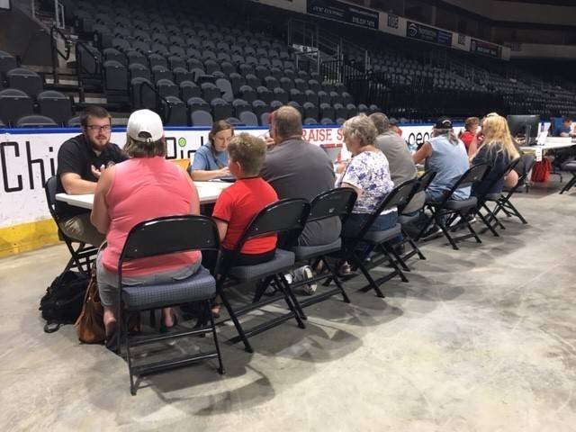 Red Cross volunteers sitting at a table talk to flood victims in Missouri