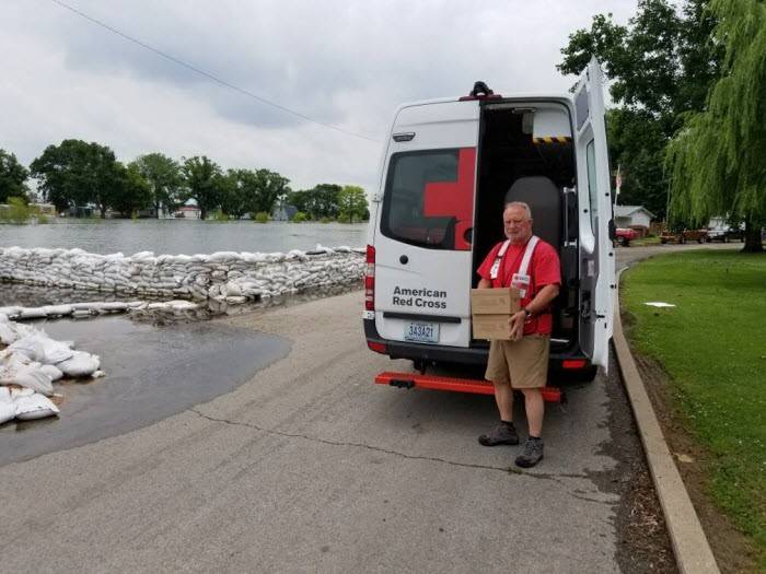 Red Cross volunteer unloading supplies from a Red Cross van delivering supplies to flood victims in Missouri.