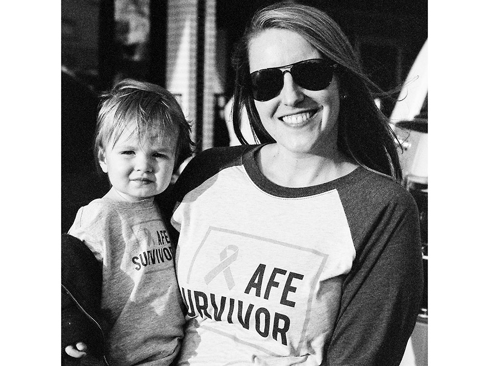 Meghan Jolliffe wearing sunglasses and holding her 8-year-old son, Sully.