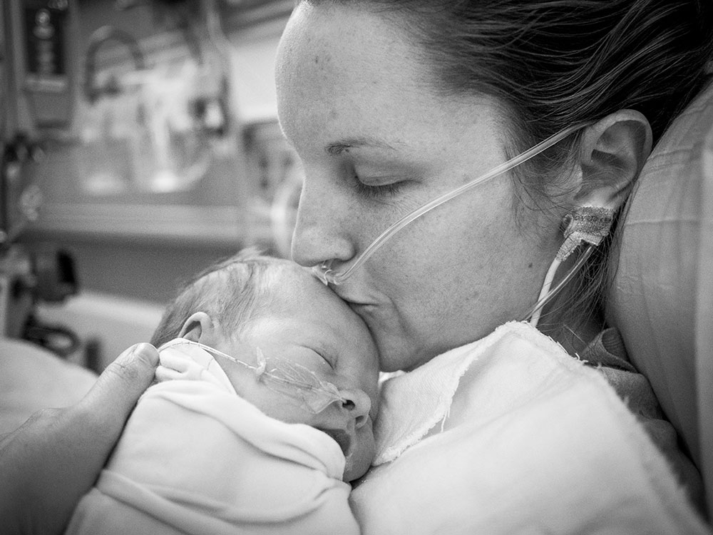 Meghan Jolliffe holding and kissing the head of her newborn son, Sully.