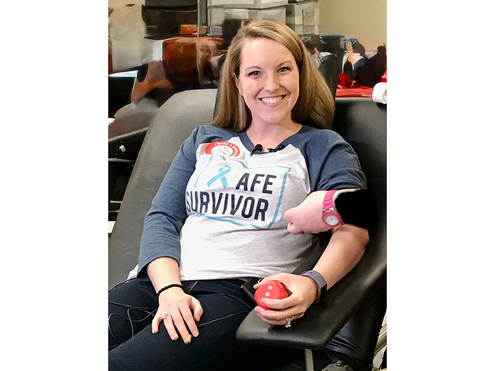 Meghan Jolliffe smiling while sitting in a chair and donating blood.