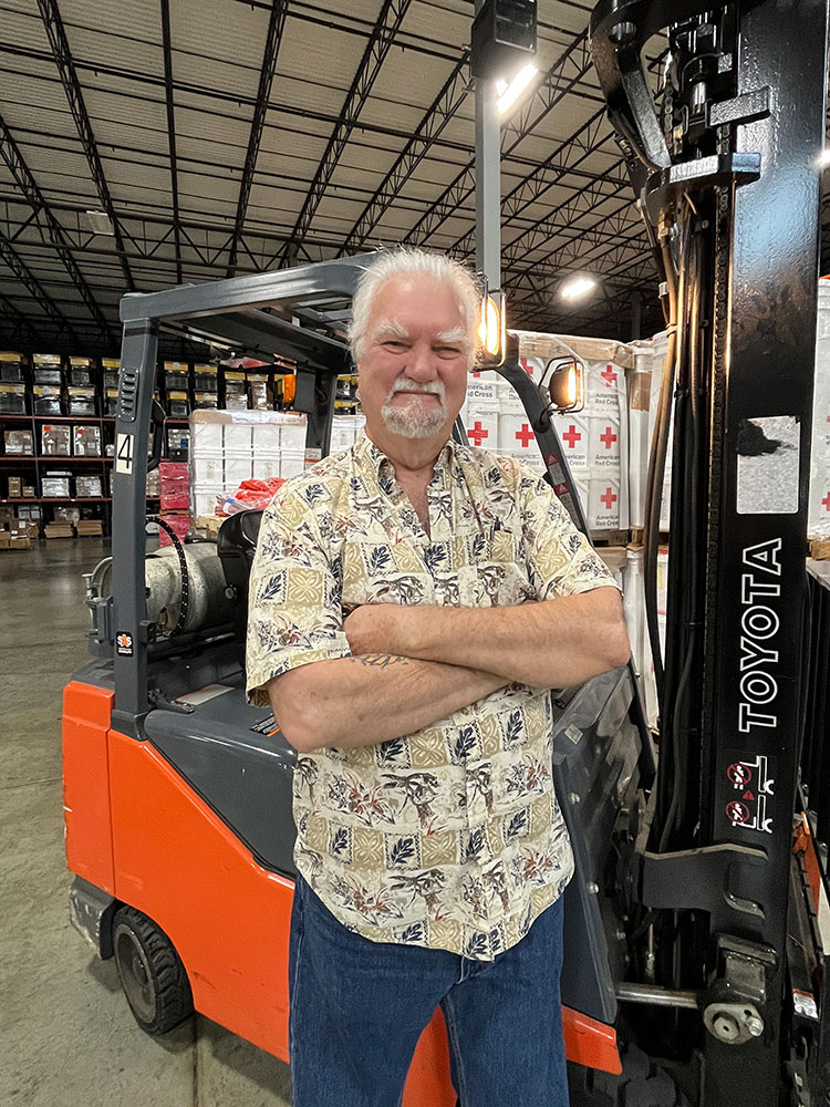 Richard Miller in front of his forklift truck at the American Red Cross warehouse.