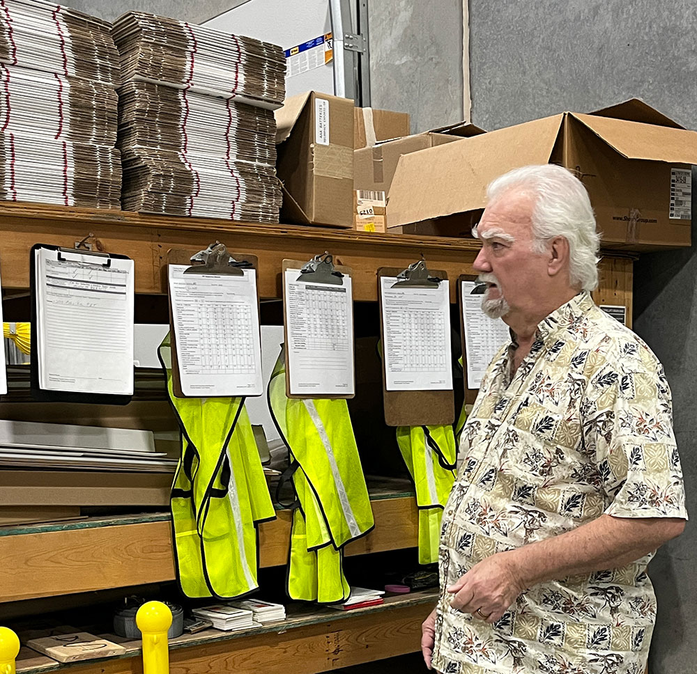Richard Miller examining inventory records, supply lists, and transport scheduling at the American Red Cross warehouse.