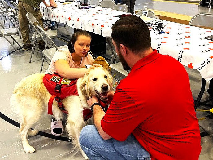 Ollie Strange playing with a service dog at the Multi-Agency Resource Center.