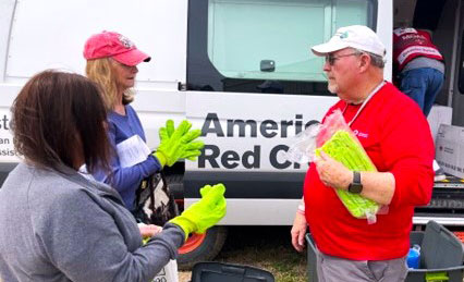 Red Cross volunteers unloading a Red Cross van.